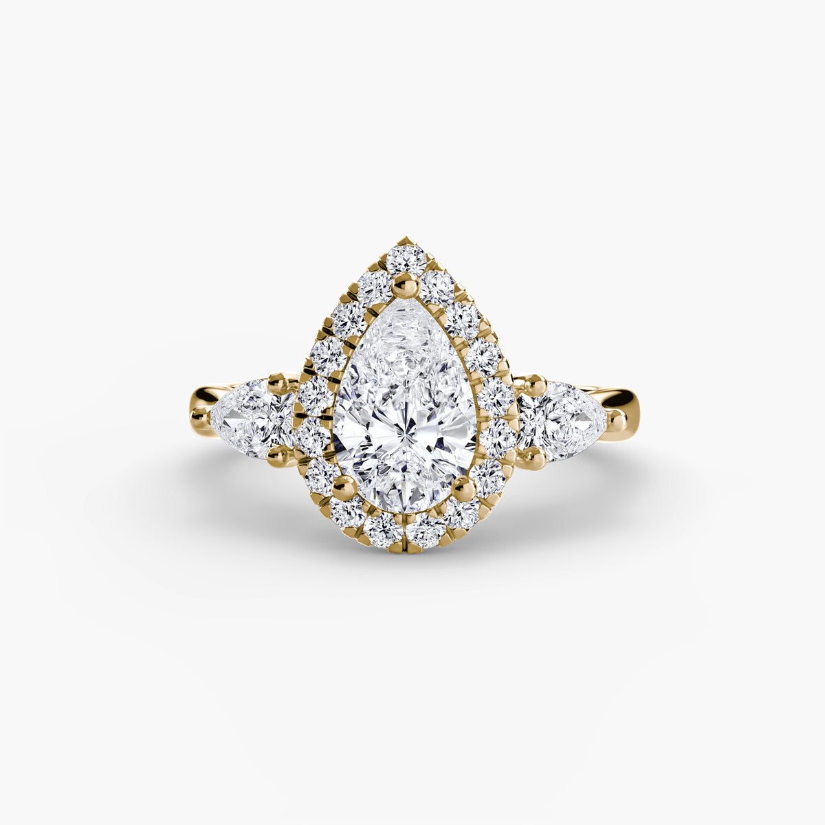 Three-Stone Ring with Halo in yellow gold with a pear-shaped centre stone