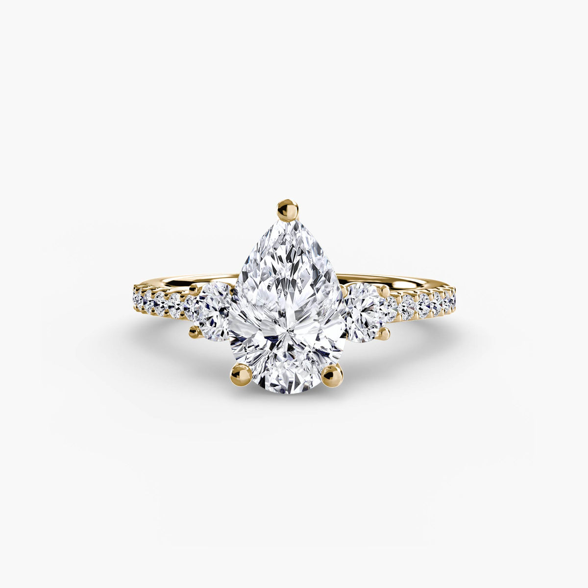 Three-Stone Ring with Pavé Band in yellow gold with a pear-shaped centre stone