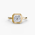 The Bezel Set Solitaire engagement ring in yellow gold with an Asscher-cut centre stone