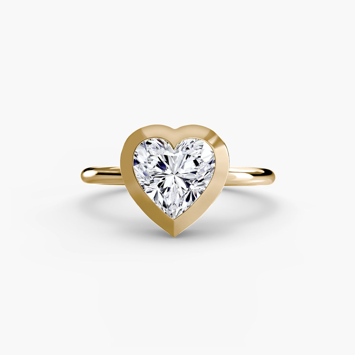 The Bezel Set Solitaire engagement ring in yellow gold with a heart-shaped centre stone