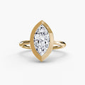 The Bezel Set Solitaire engagement ring in yellow gold with a marquise centre stone