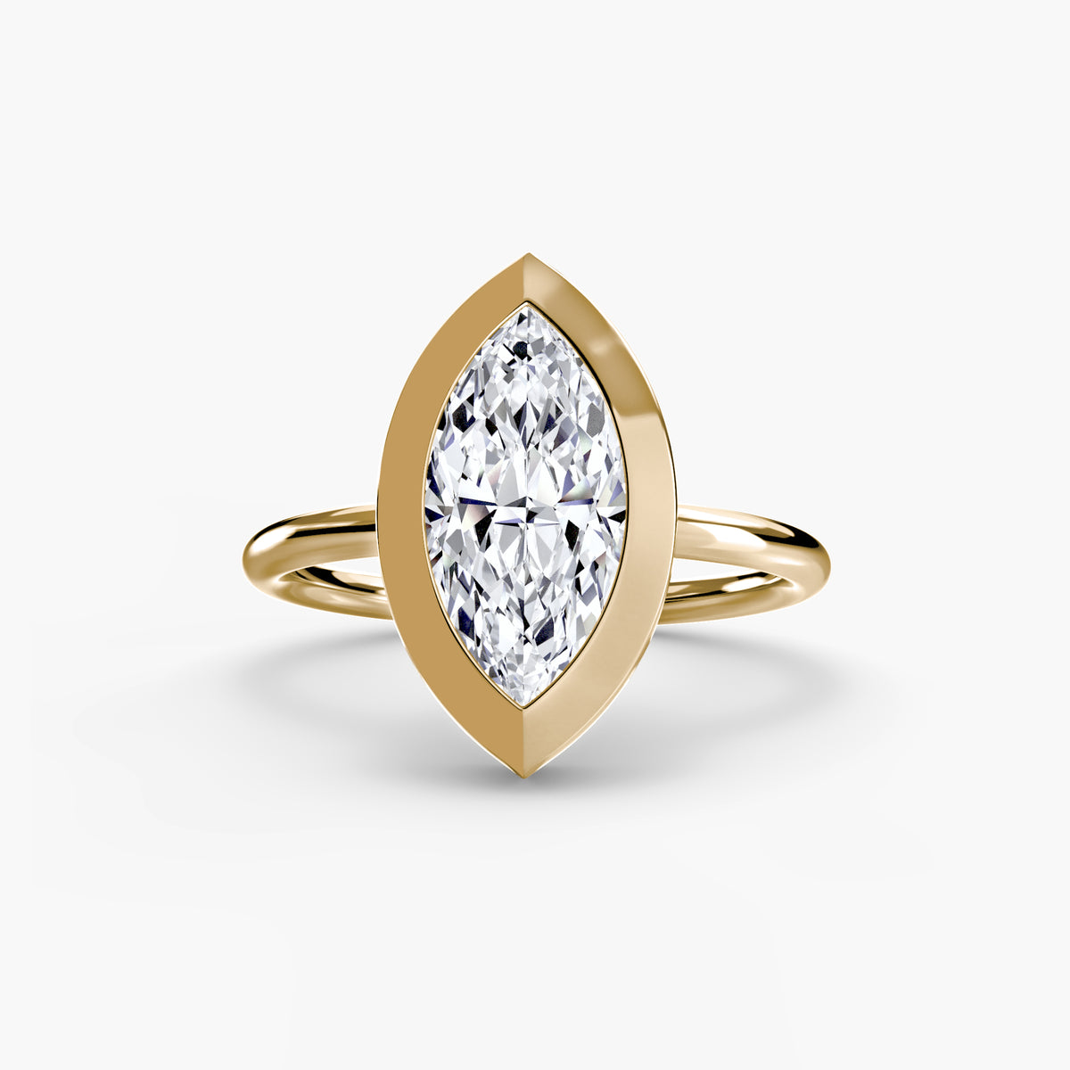 The Bezel Set Solitaire engagement ring in yellow gold with a marquise centre stone