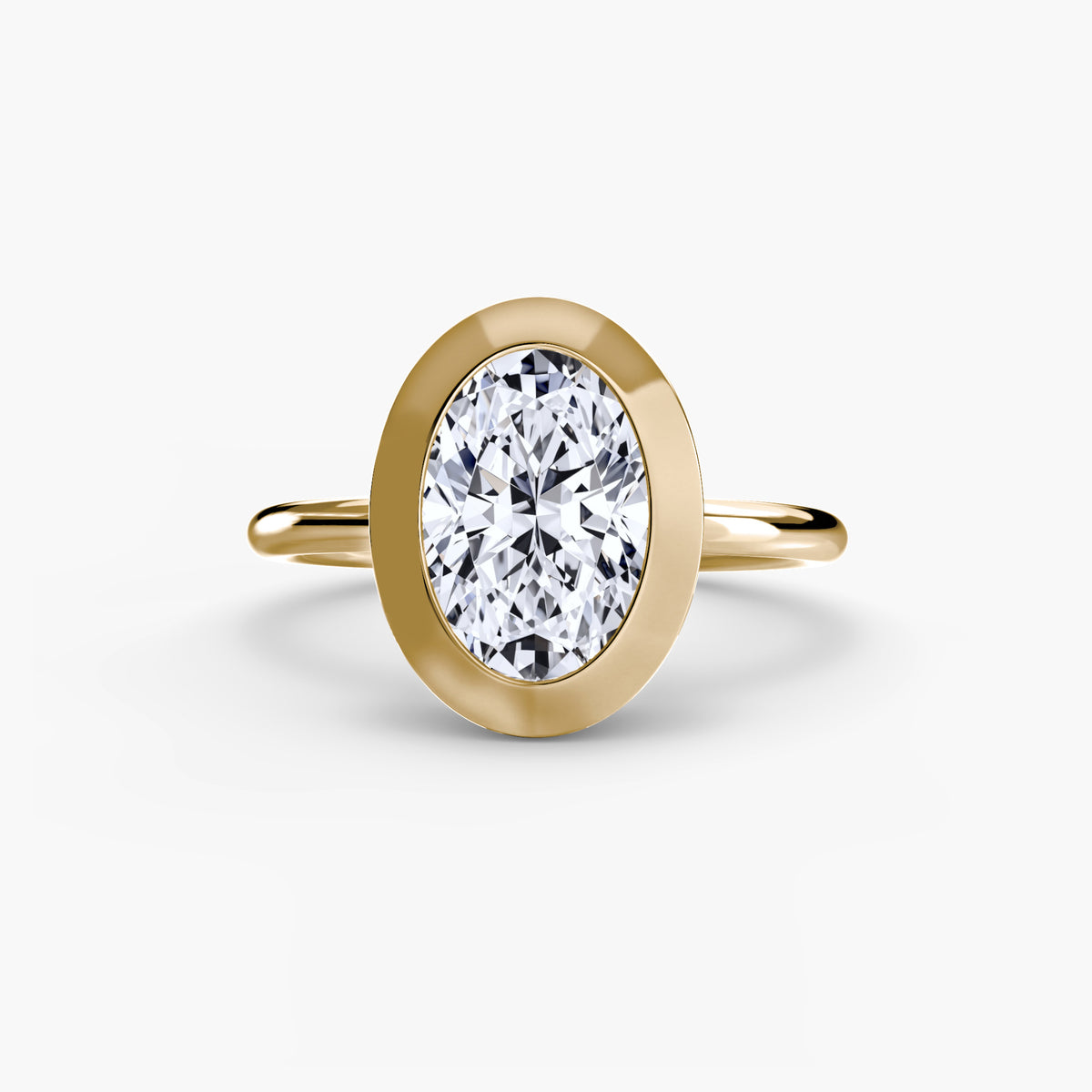 The Bezel Set Solitaire engagement ring in yellow gold with an oval centre stone