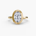 The Bezel Set Solitaire engagement ring in yellow gold with an oval centre stone