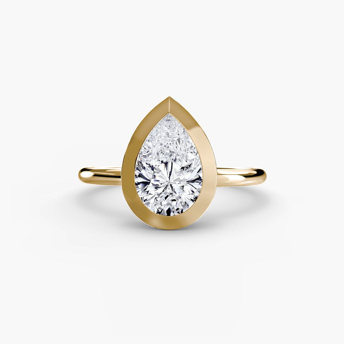 The Bezel Set Solitaire engagement ring in yellow gold with a pear-shaped centre stone