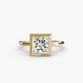The Bezel Set Solitaire engagement ring in yellow gold with a princess-cut centre stone