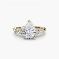 The Floral Accent Solitaire engagement ring in yellow gold with a pear-shaped centre stone