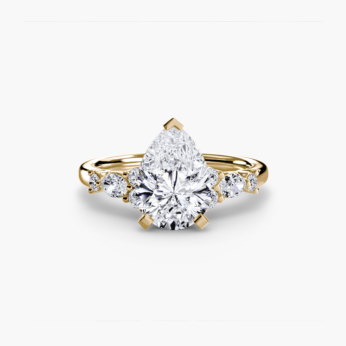 The Floral Accent Solitaire engagement ring in yellow gold with a pear-shaped centre stone