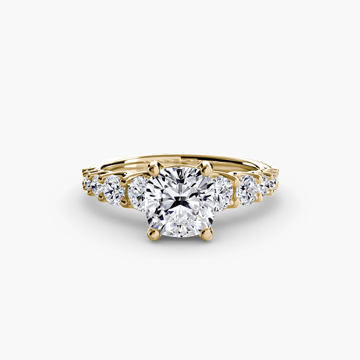 The Graduated Accent Ring in yellow gold with a cushion-cut centre stone
