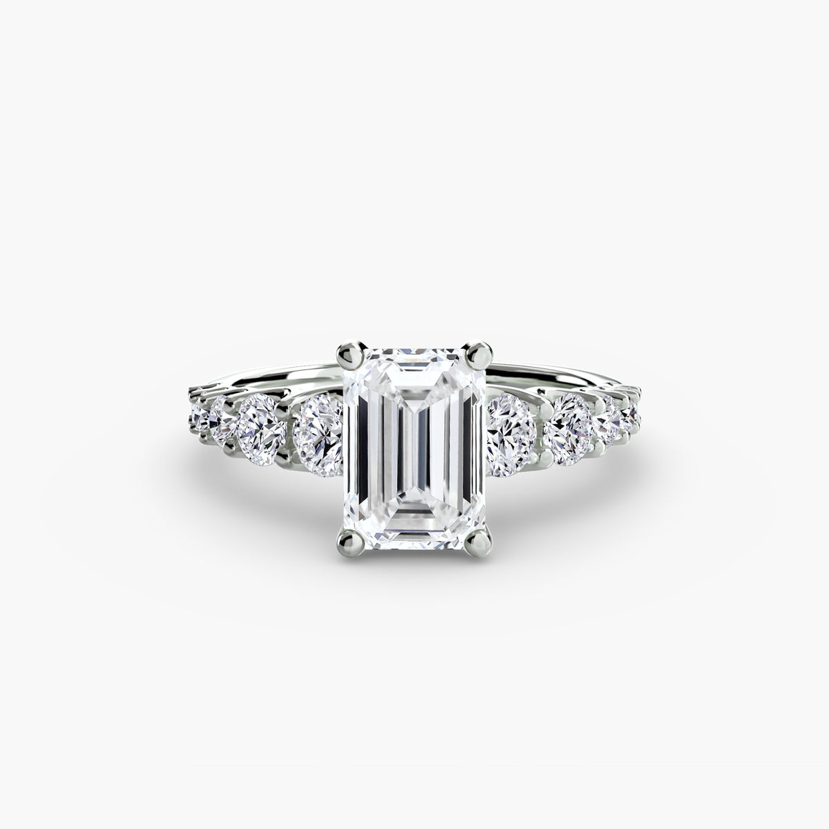 The Graduated Accent Ring in white gold with an emerald-cut centre stone