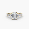 The Graduated Accent Ring in yellow gold with an emerald-cut centre stone
