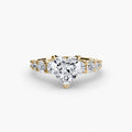 The Graduated Accent Ring in yellow gold with a heart-shaped centre stone