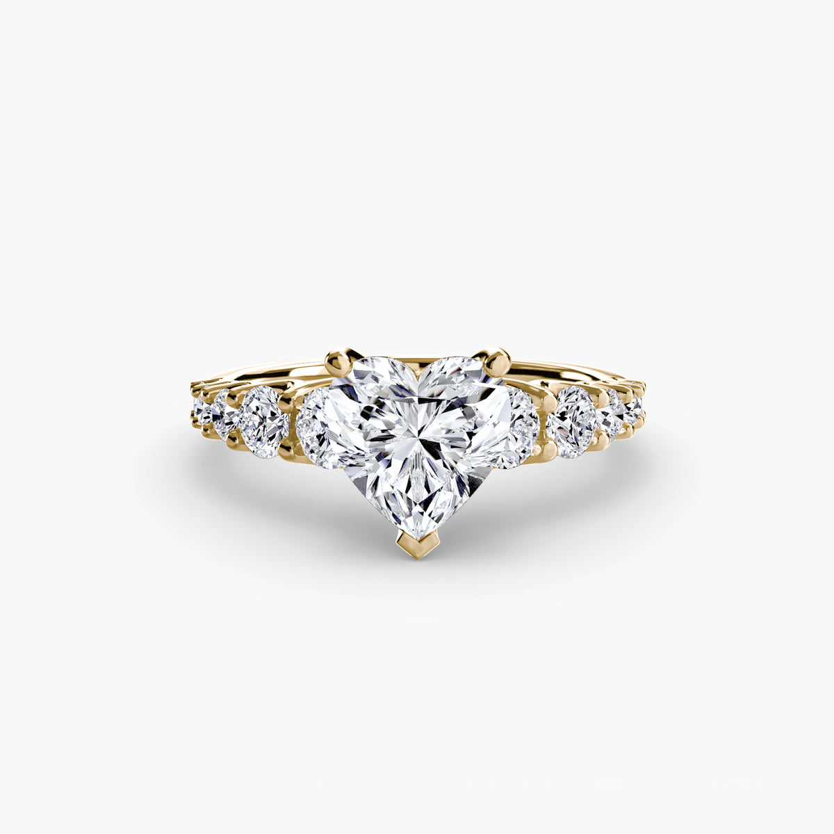 The Graduated Accent Ring in yellow gold with a heart-shaped centre stone