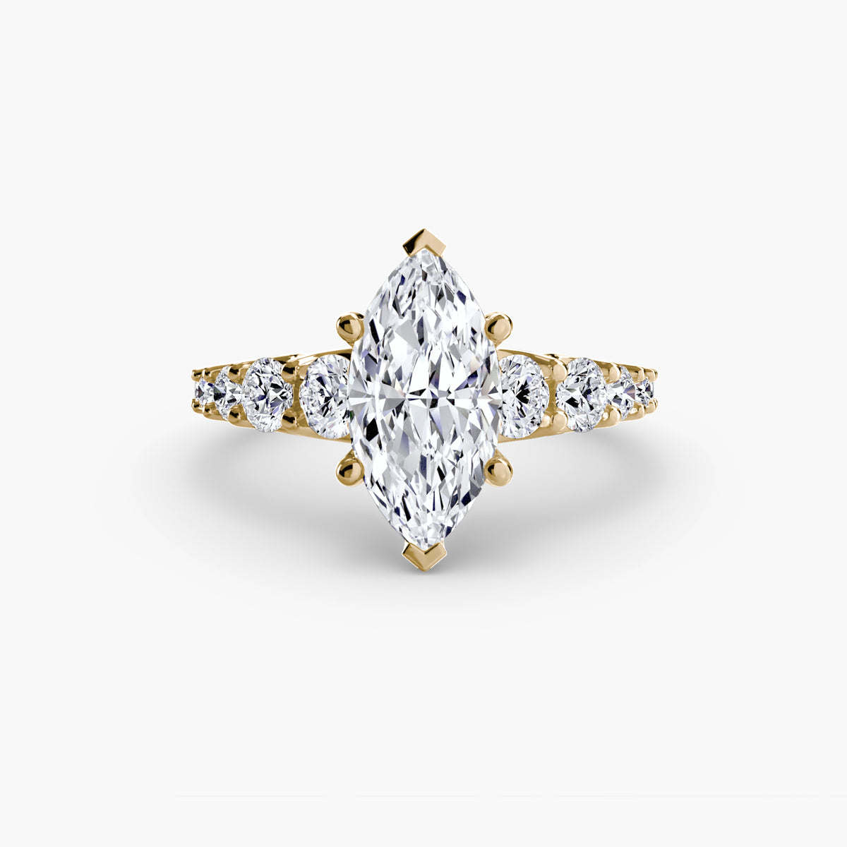 The Graduated Accent Ring in yellow gold with a marquise centre stone