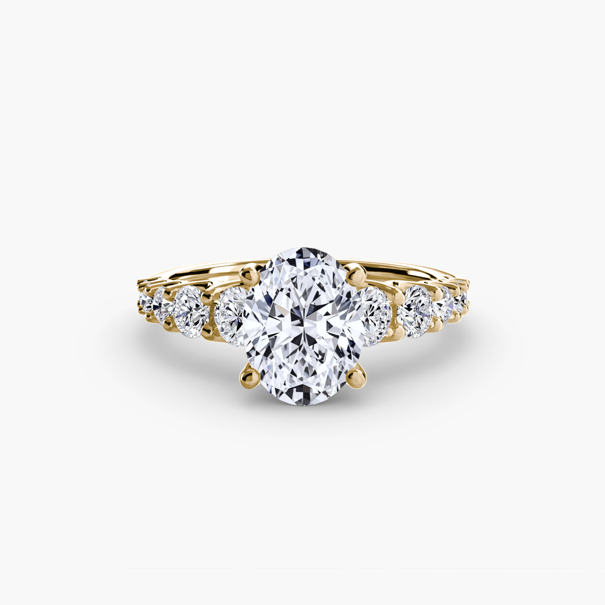 The Graduated Accent Ring in yellow gold with an oval centre stone