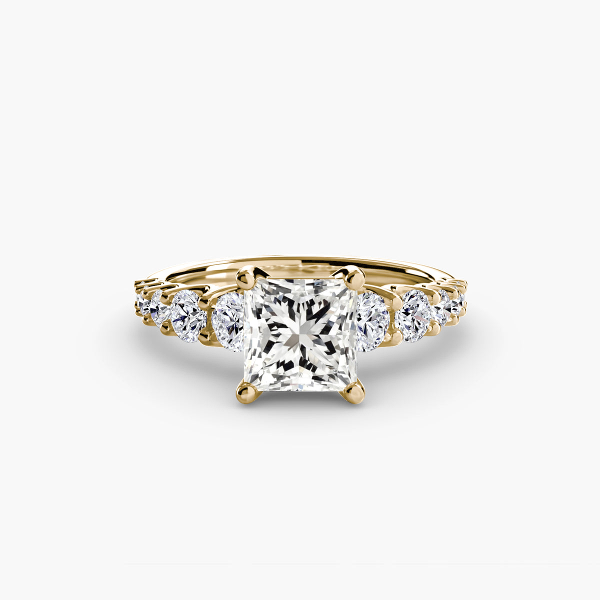 The Graduated Accent Ring in yellow gold with a princess-cut centre stone