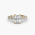The Graduated Accent Ring in yellow gold with a radiant-cut centre stone