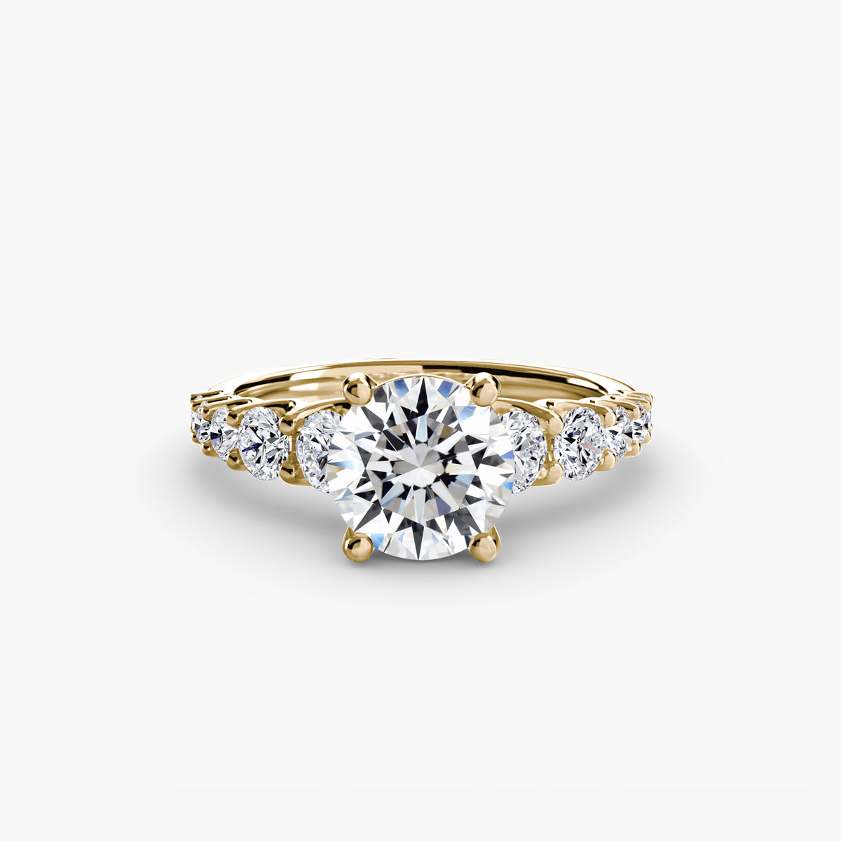The Graduated Accent Ring in yellow gold with a round centre stone
