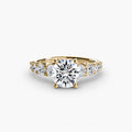 The Graduated Accent Ring in yellow gold with a round centre stone