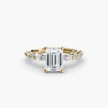 The Tiered Accent Ring in yellow gold with an emerald-cut centre stone