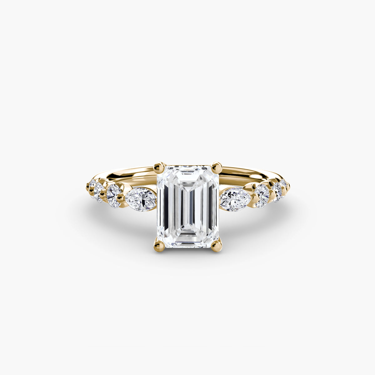 The Tiered Accent Ring in yellow gold with an emerald-cut centre stone
