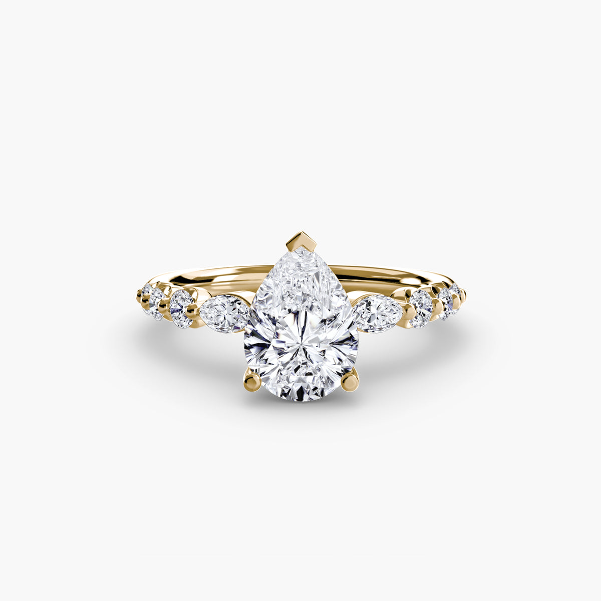 The Tiered Accent Ring in yellow gold with a pear-shaped centre stone