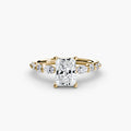 The Tiered Accent Ring in yellow gold with a radiant-cut centre stone