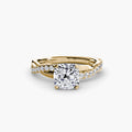 The Emerald Twist Pavé Ring in yellow gold with a cushion-cut centre stone