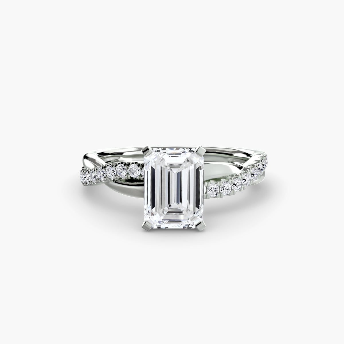 The Emerald Twist Pavé Ring in white gold with an emerald-cut centre stone