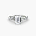 The Emerald Twist Pavé Ring in white gold with an emerald-cut centre stone