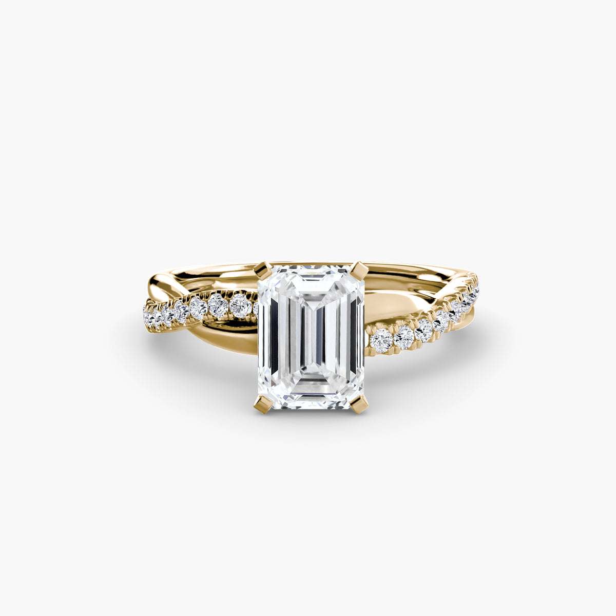 The Emerald Twist Pavé Ring in yellow gold with an emerald-cut centre stone