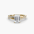 The Emerald Twist Pavé Ring in yellow gold with an emerald-cut centre stone