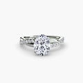The Emerald Twist Pavé Ring in white gold with an oval centre stone