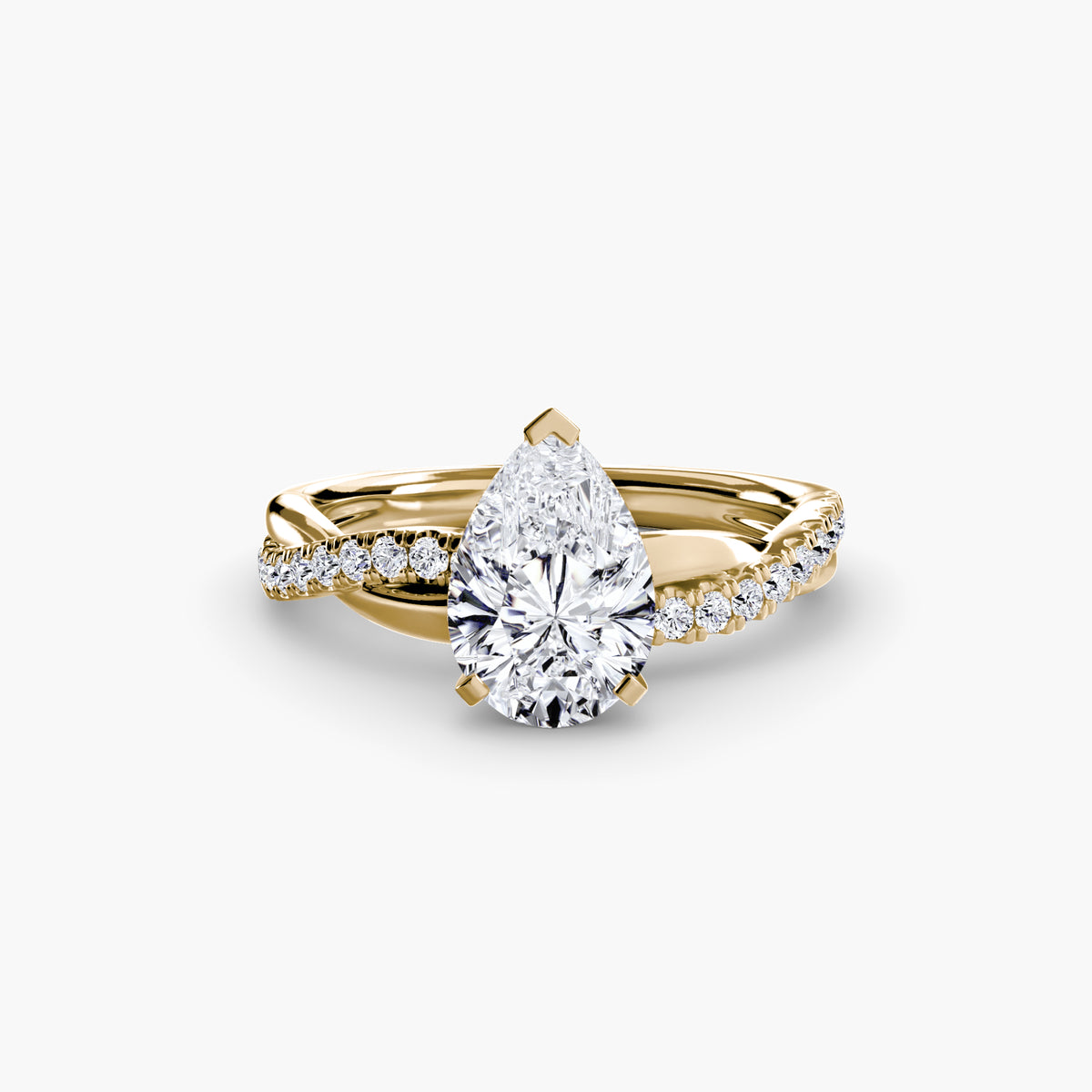 The Emerald Twist Pavé Ring in yellow gold with a pear-shaped centre stone