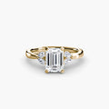 The Celestial Cluster Ring in yellow gold with an emerald-cut centre stone