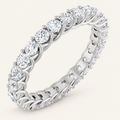 Natural diamond full eternity ring with interwoven claw design in white metal on an ivory background