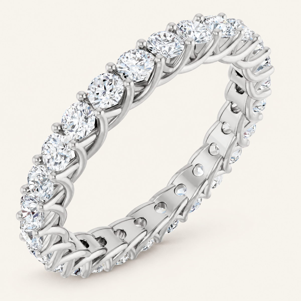 Natural diamond full eternity ring with interwoven claw design in white metal on an ivory background